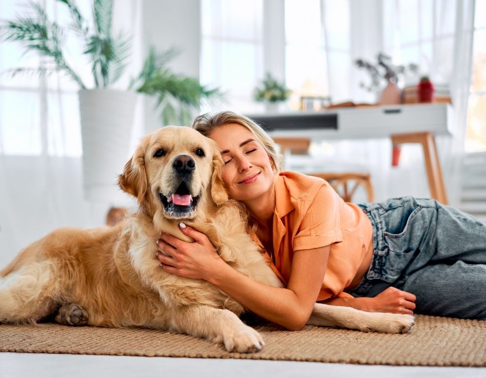 A girl hugging a brown dog indoor