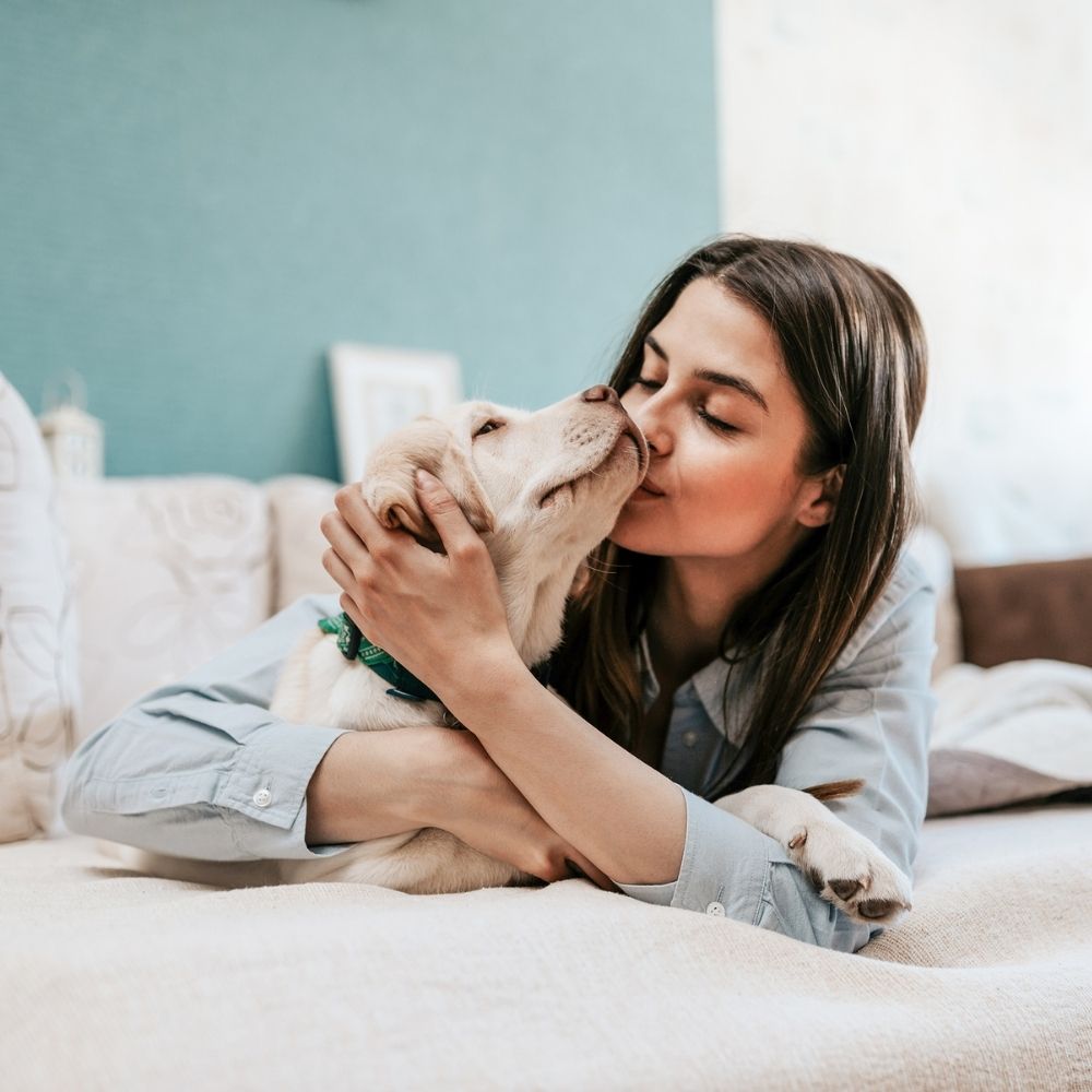 30 girl kissing a dog indoor
