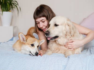 women sitting with dog on the bed